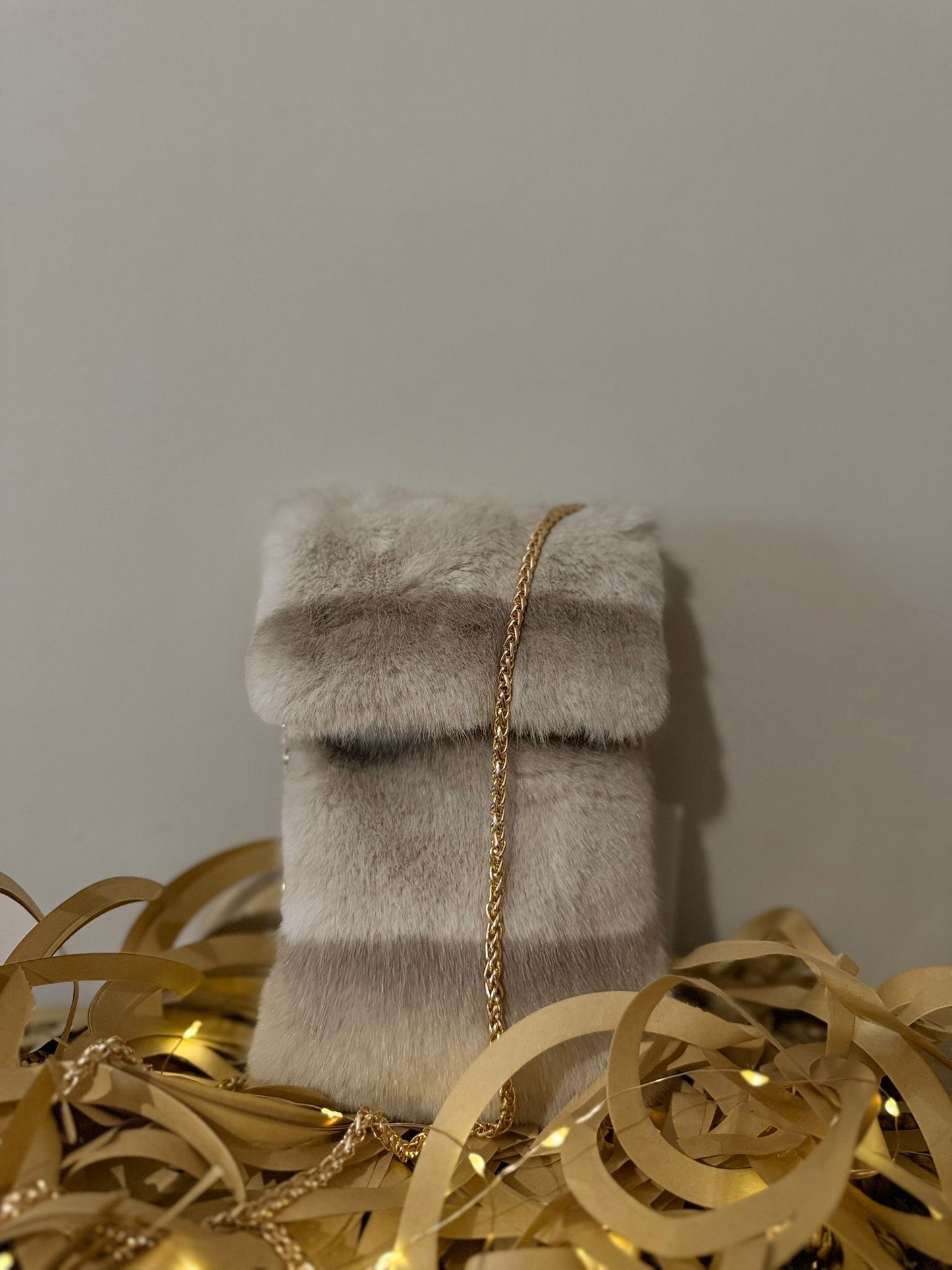 Porta cellulare in pelliccia con catena in oro