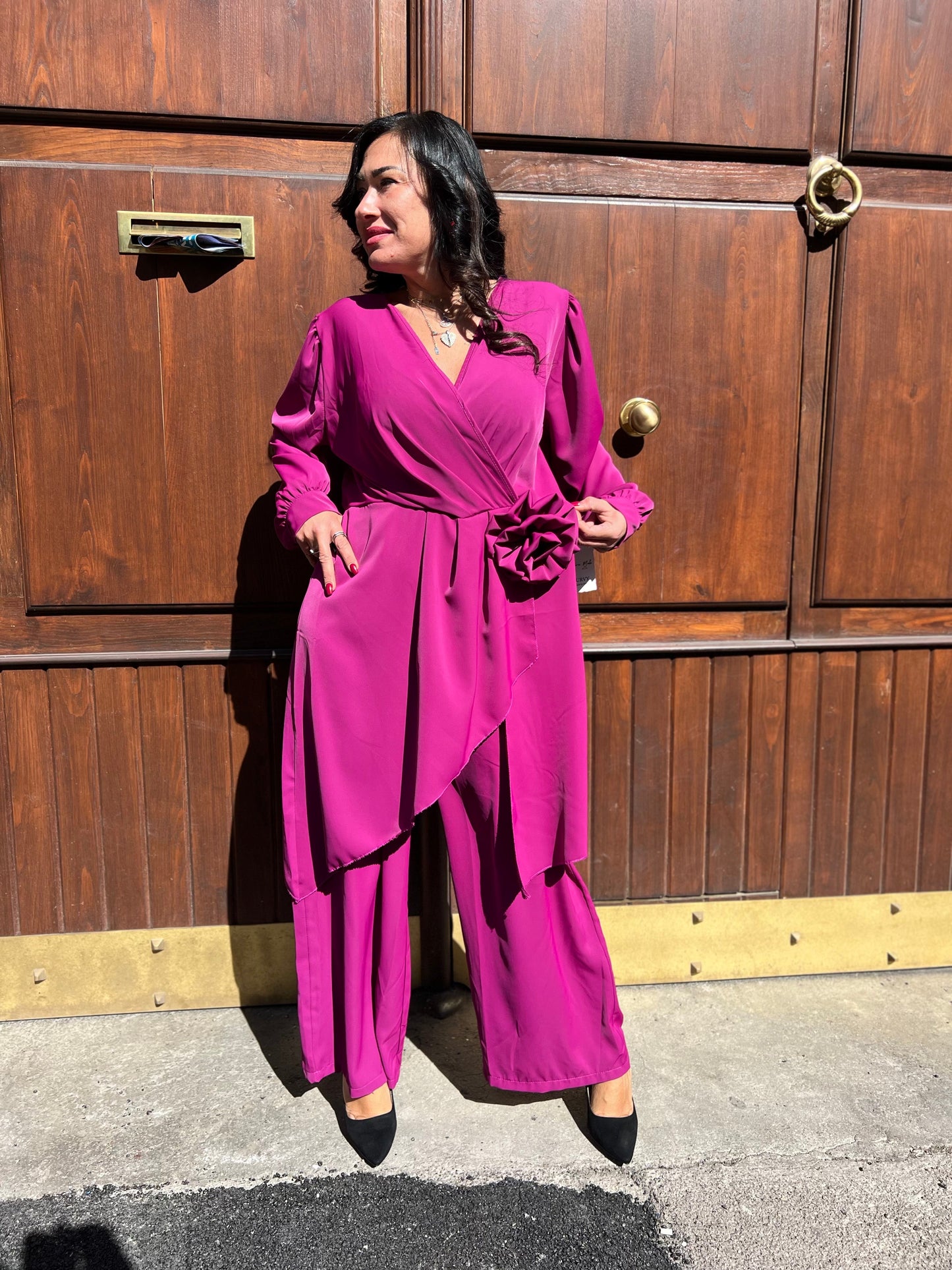 Tuta intera elegante curvy con fiore e casacca asimmetrica – disponibile in nero, prugna e marrone